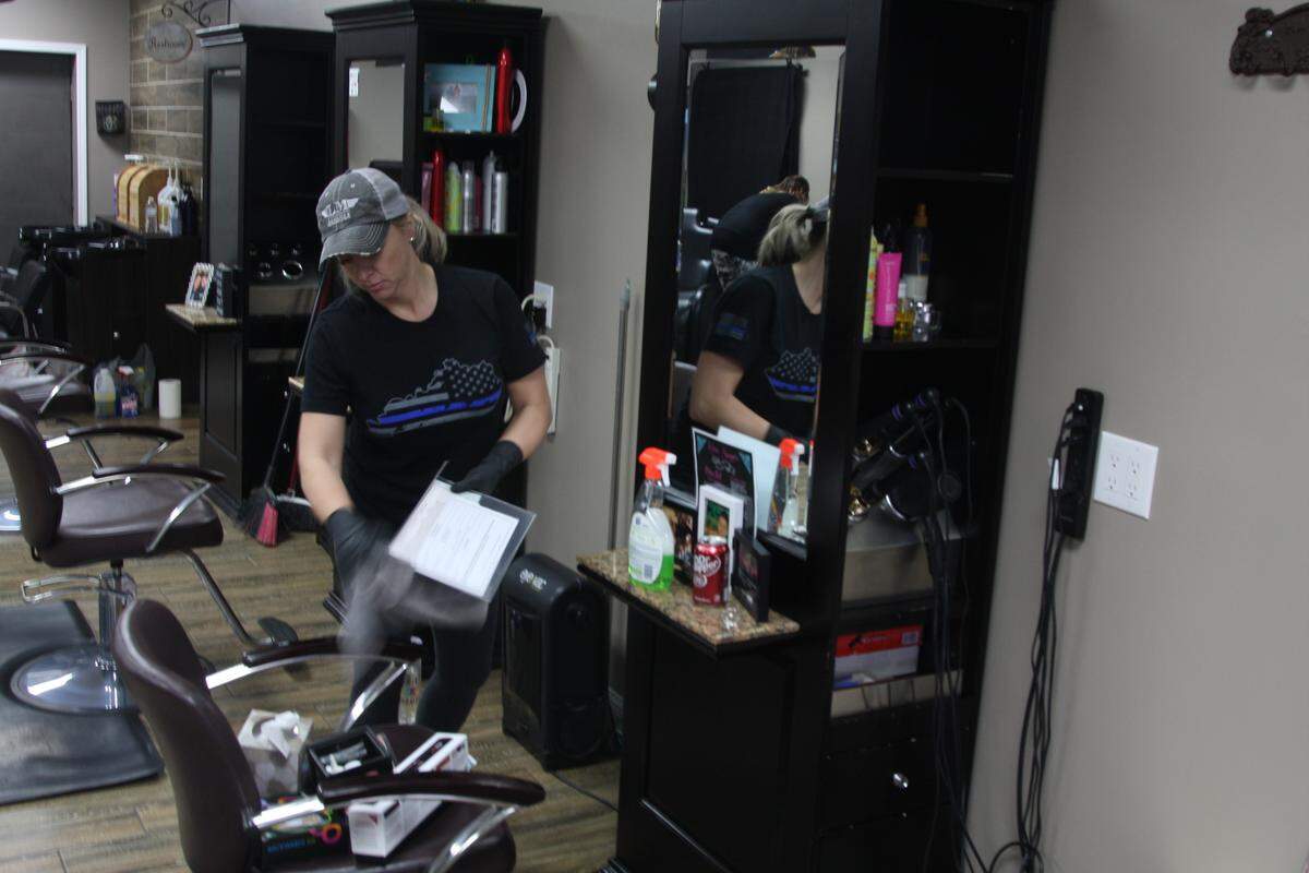 Kerri Salyers, salon manager at Expressions Salon in Pikeville, cleans a work station on Monday as the store prepares for an extended closure.
