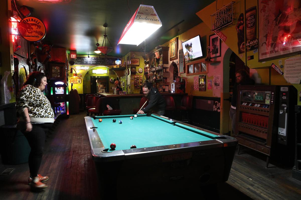 Co-owner Erin Reynolds played pool with a patron Wednesday night before the rush at Green Lantern Bar at 497 West Third St. in Lexington.