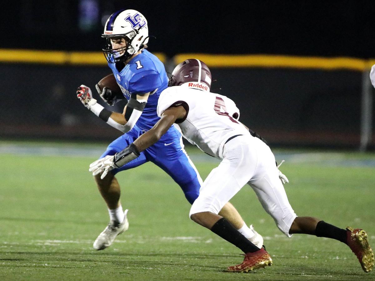 Lexington Catholic’s Max DeGraff tries to avoid the tackle of Tates Creek’s Kobe Middleton on Friday night.