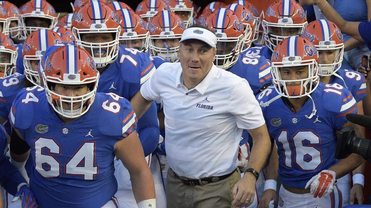 After going 8-1 against Kentucky as Mississippi State head coach, Dan Mullen, center, has moved to Florida -- a football program that has beaten UK 31 games in a row.