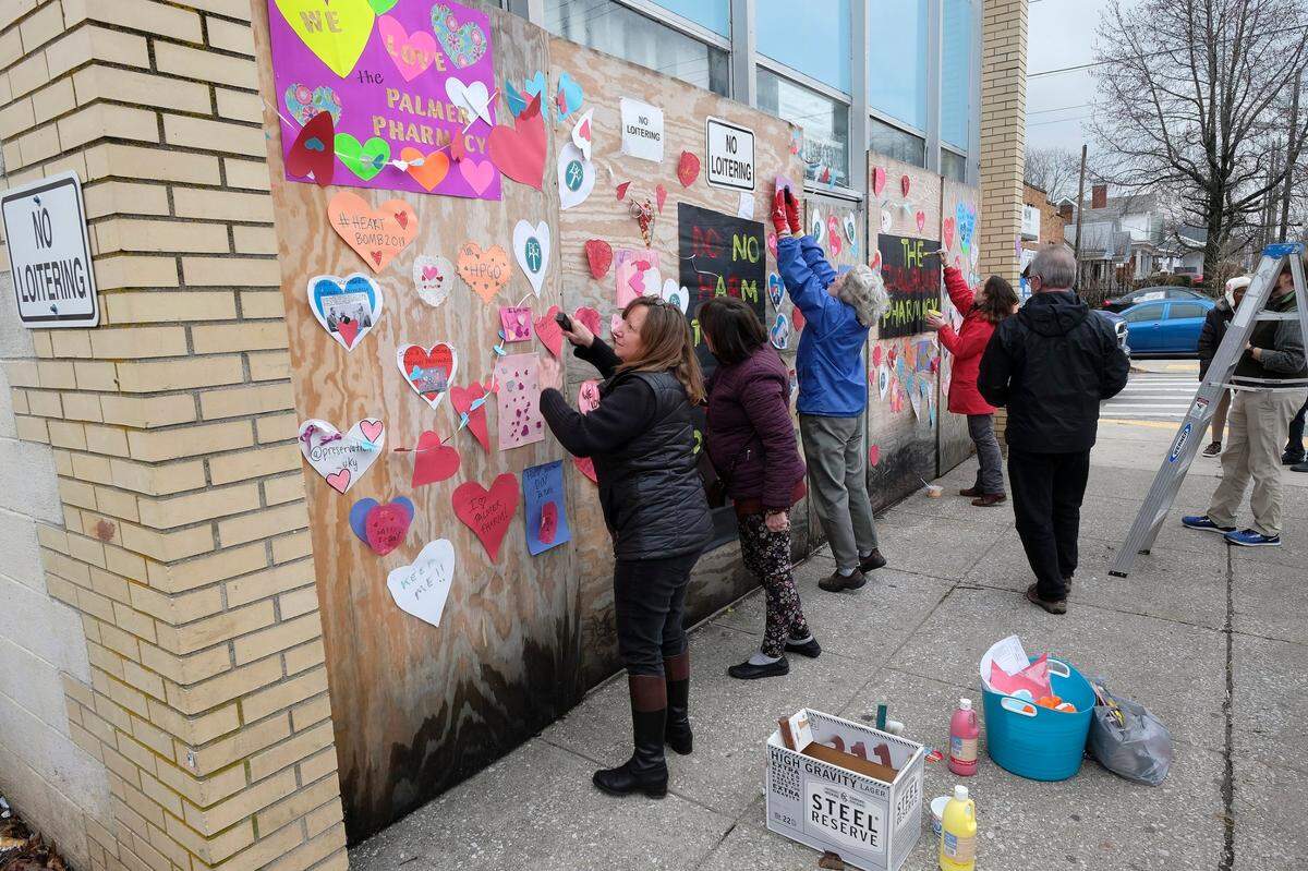 Maureen Peters, left, and other preservationists put valentines on plywood covering the front windows of the former Palmer Pharmacy on East Fifth Street on Feb. 16, 2018. They were hoping to save and reuse the city-owned building, built in 1961 by pioneering Black pharmacist Zirl A. Palmer.