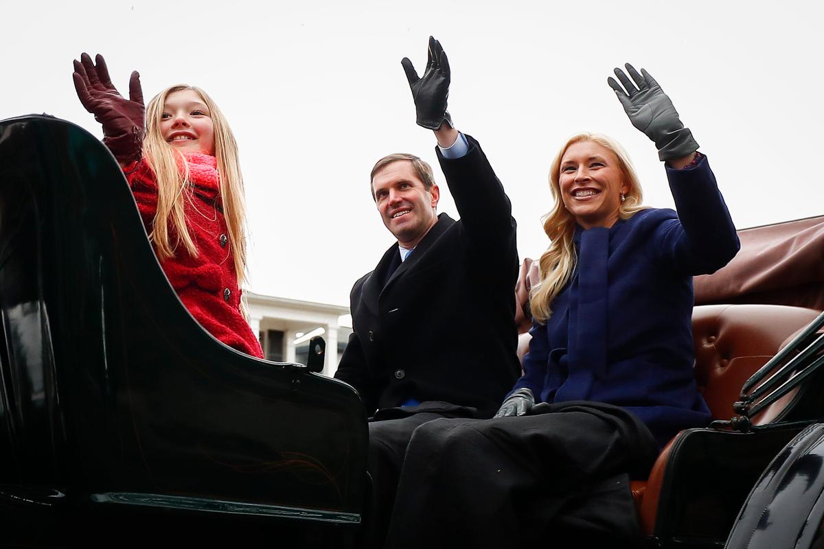 Gov. Andy Beshear, center, waves to supporters with his daughter Lila Beshear, left, and wife Britainy Beshear during the inaugural parade along Capital Avenue in Frankfort, Ky., Tuesday, Dec. 10, 2019.
