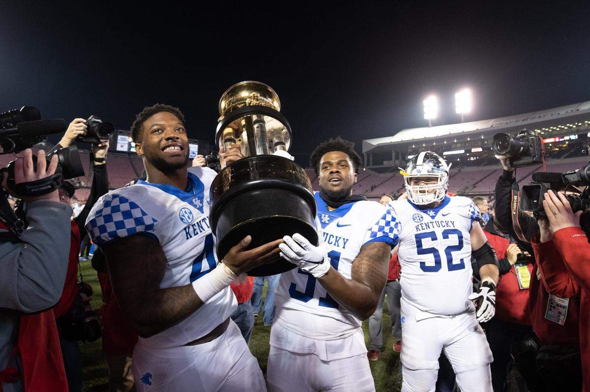 Kentucky linebackers Josh Allen (41) and Jamar “Boogie” Watson (31) hoist the Governor’s Cup trophy after the Wildcats demolished intrastate rival Louisville 56-10 in 2018. UK has now beaten the Cardinals four games straight and in five of the past six meetings.