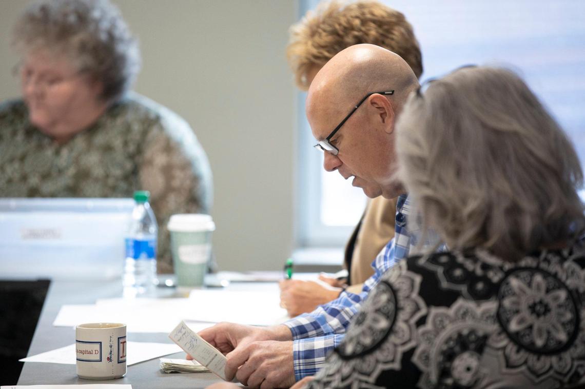 Fayette County Clerk Don Blevins Jr., second from right, reads out vote totals from voting machine tapes during a recanvass at the Fayette County Clerk’s office in Lexington, Ky., Thursday, Nov. 14, 2019.