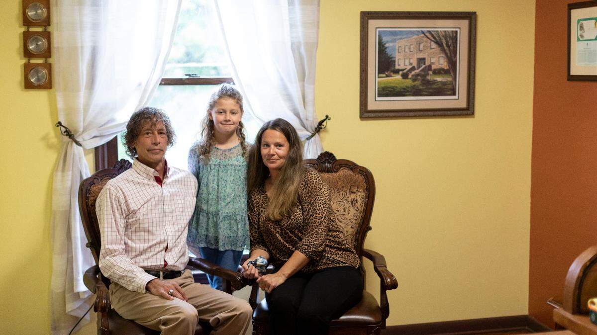 Nine-year old Althea Blake Madden poses for a portrait with her mother Kerri and father Jared in his office for osteopathic medicine in Manchester, Ky., Wednesday, September 22, 2021. Alie Blake is part of a clinical trial testing the Moderna vaccine for approved on children under 12.