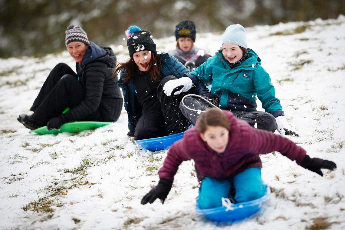 Alex Bybee, from left, Sophie McBride, 10, Iris Gorham, 7, Emma Harris, 12, and Katie McBride, 12, front, all of Lexington, Ky., sled down the hill near the old Shriner’s Hospital in Lexington, Friday, Feb. 7, 2020.