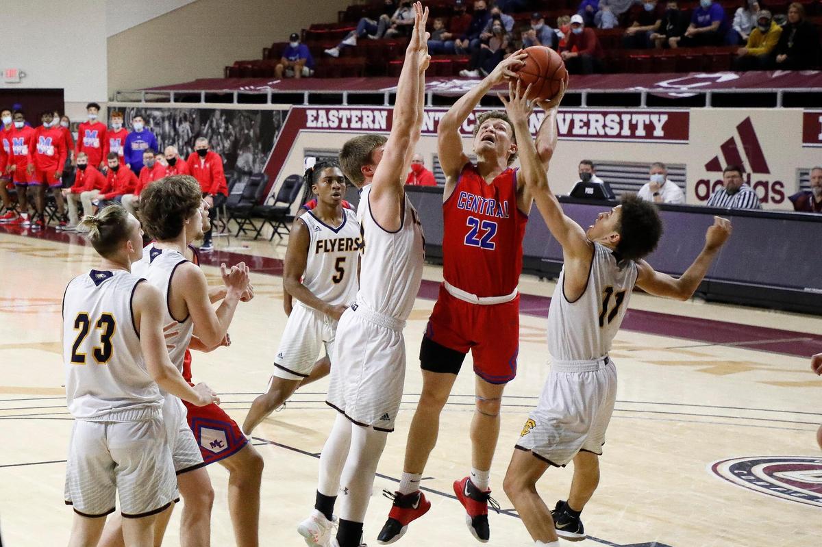 Madison Central’s Kole Browne (22) shoots between Franklin County’s Phillip Peiffer (34) and Jayden Mattison (11) during the 11th Region Tournament semifinals at McBrayer Arena in Richmond. Madison Central beat Franklin County 67-51.