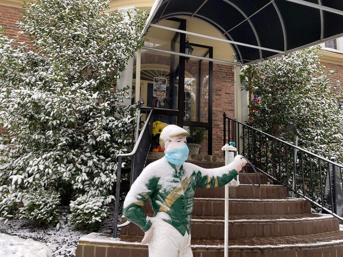 A lawn jockey wears a mask in front of the entrance to Merrick Inn restaurant Tuesday, Dec. 1, 2020. The long-standing Lexington restaurant announced it would shutdown until spring or until we receive some kind of relief from Governor Beshear’s mandates because of the pandemic.