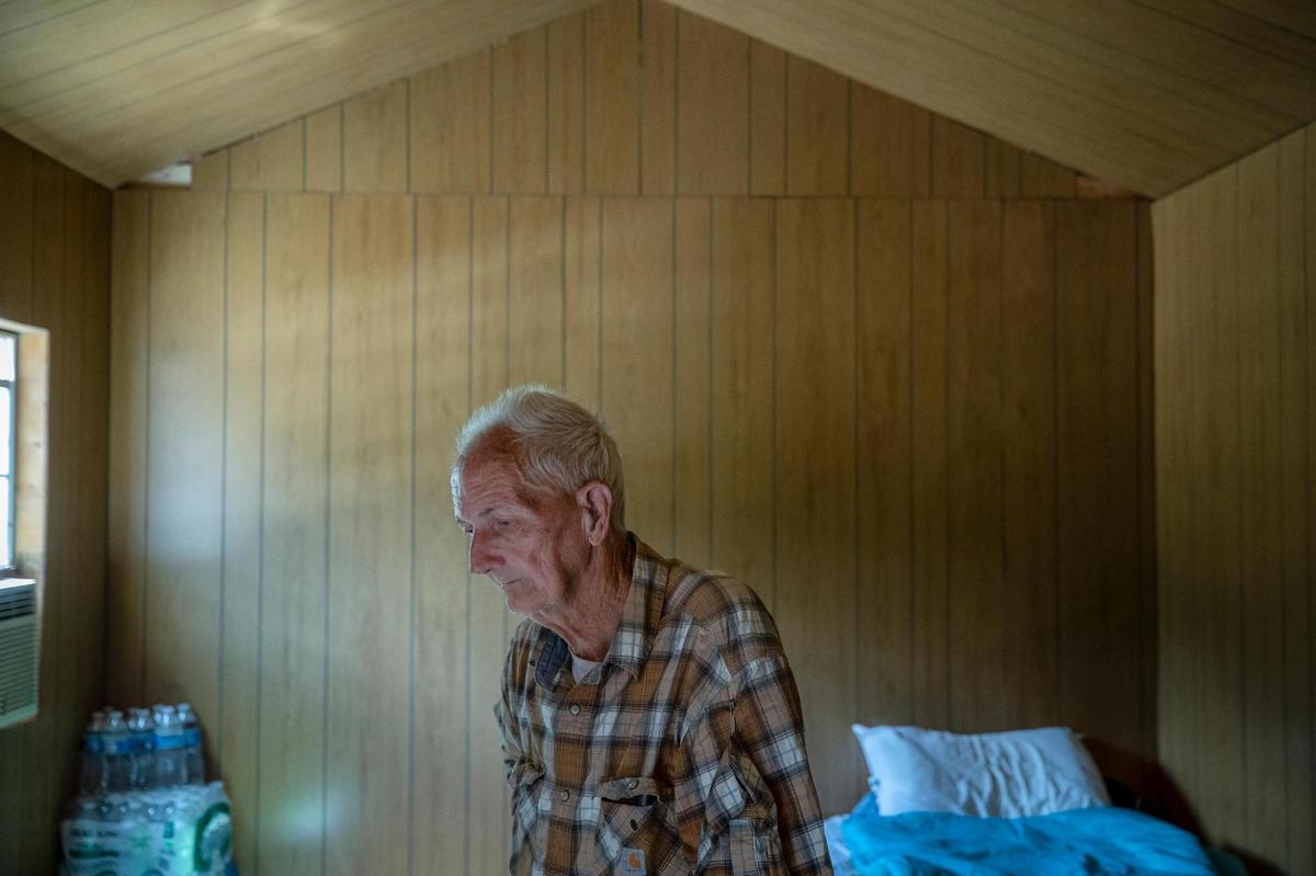 Andrew Fugate, 75, stands inside a storage unit he bought to live in after his house in Perry County, Ky., flooded last month. The storage unit is setup in the driveway at his old house, but he plans to move it to a spot nearby on higher ground.