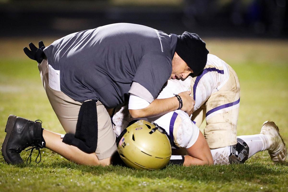 Somerset defensive line coach Kevin Sharon comforts Kaiya Sheron (2) after the Briar Jumpers’ loss to Lexington Christian Academy on Friday.