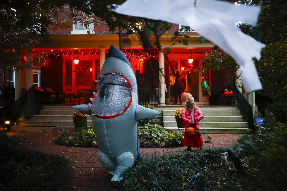 Finley Insko, 12, left, and Ellen James Hilton, 6, both of Lexington, Ky., leave a house after receiving candy while trick-or-treating along Sayre Avenue in Lexington, Thursday, Oct. 31, 2019.