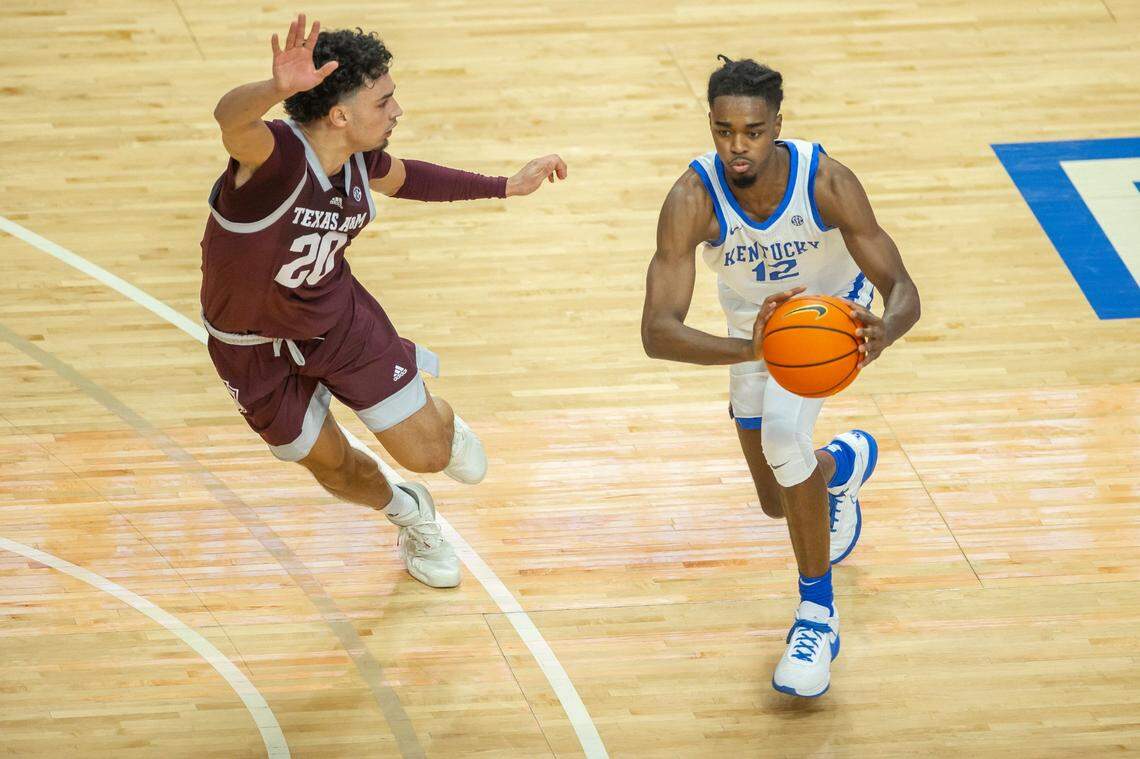 Kentucky guard Antonio Reeves (12) looks to pass the ball as Texas A&M guard Andre Gordon (20) plays defense during Saturday’s game.