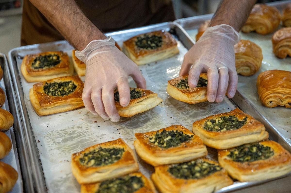 Andy Bissell removes spinach and feta pastries from the oven.
