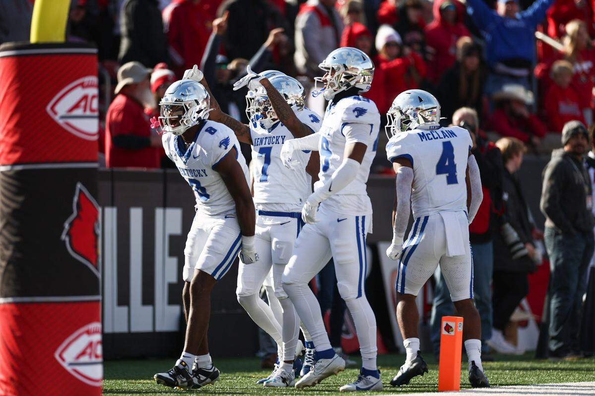 Kentucky’s Barion Brown, left, celebrates with his teammates after returning a kickoff for a touchdown against Louisville.