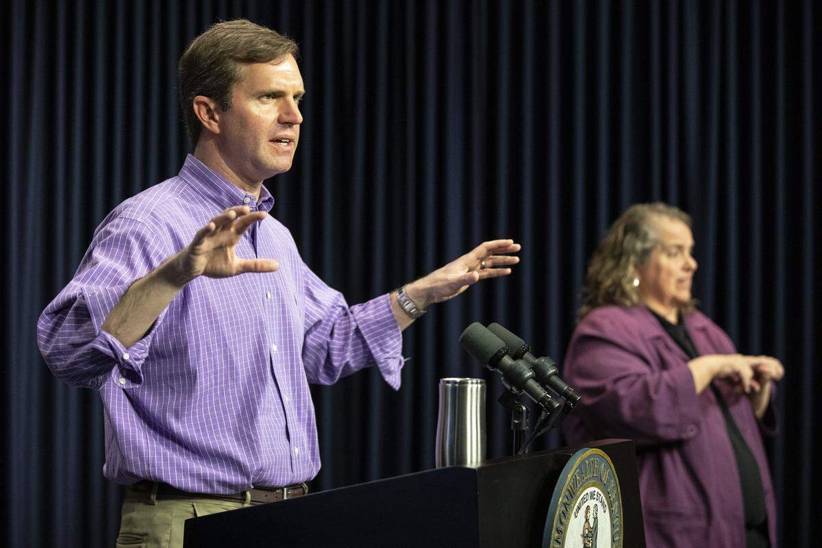 Kentucky Gov. Andy Beshear speaks while Virginia Moore, an American Sign Language interpreter and executive director of the Kentucky Commission on the Deaf and Hard of Hearing, signs during a media conference at the state Capitol in Frankfort, Ky., to provide an update on the novel coronavirus on Sunday, March 29, 2020