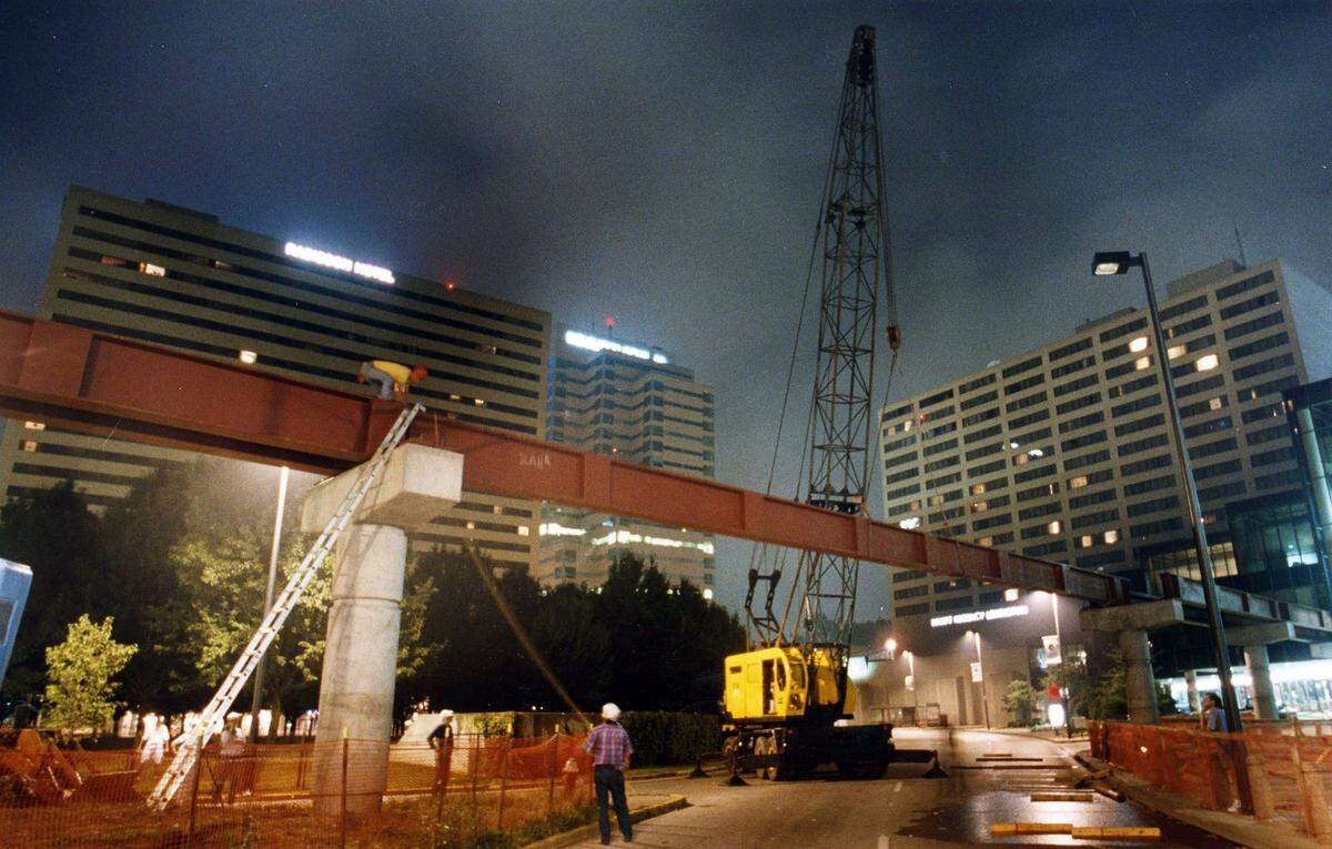 Workers erected one of the last beams supporting a walkway leading from the second floors of Victorian Square to the Lexington Center, July 17, 1993. Parts of Main and Vine streets were closed during the overnight hours as the 96-foot, 43,000-pound beam was put in position. The pedway opened later in the fall, giving pedestrians the ability to to walk through a complete circuit of enclosed passageways linking the Radisson Plaza Hotel, the Market Place, Victorian Square and the Lexington Center.