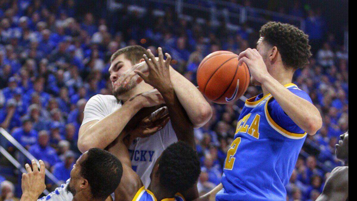 Kentucky's Isaac Humphries, top left, and Isaiah Briscoe, bottom left, scrambled for control of the ball against UCLA on Saturday afternoon in Rupp Arena.
