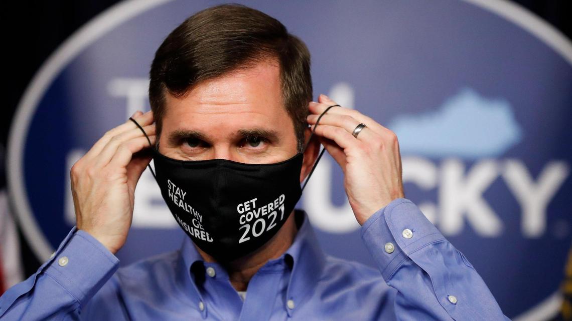 Kentucky Gov. Andy Beshear puts on his mask following a coronavirus briefing at the state Capitol in Frankfort, Ky., Thursday, Dec. 3, 2020.