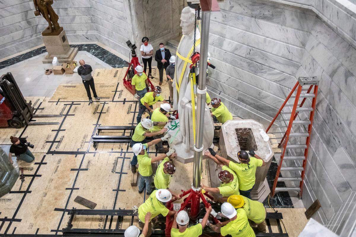 Workers remove the Jefferson Davis statue from its pedestal in the rotunda at the Kentucky state Capitol in Frankfort, Ky., on Saturday, June 13, 2020.