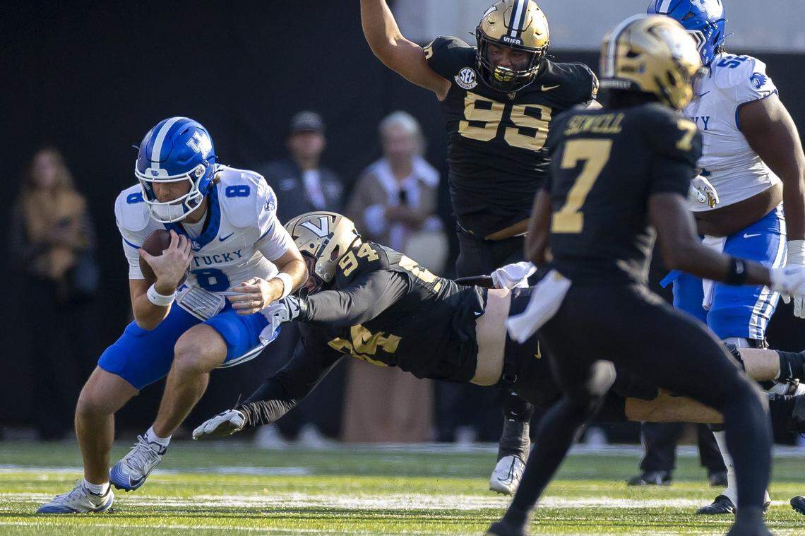 Kentucky quarterback Cutter Boley (8) runs the ball as Vanderbilt defensive lineman Bradley Mann (94) tries to wrap him up during Saturday’s game at FirstBank Stadium in Nashville, Tennessee.