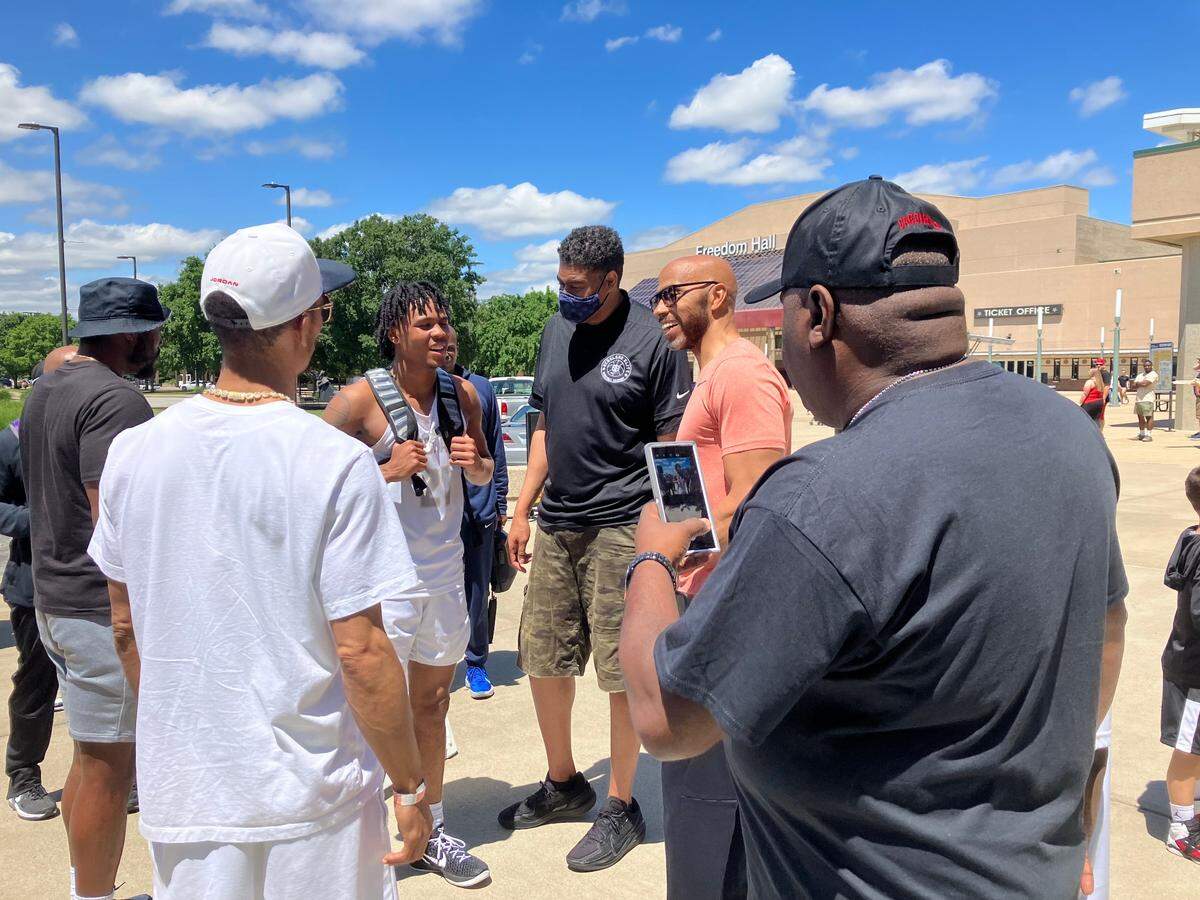 From left, DJ Wagner, Pervis Ellison and Darrell Griffith chat outside the Kentucky Exposition Center in Louisville following a Nike EYBL game.