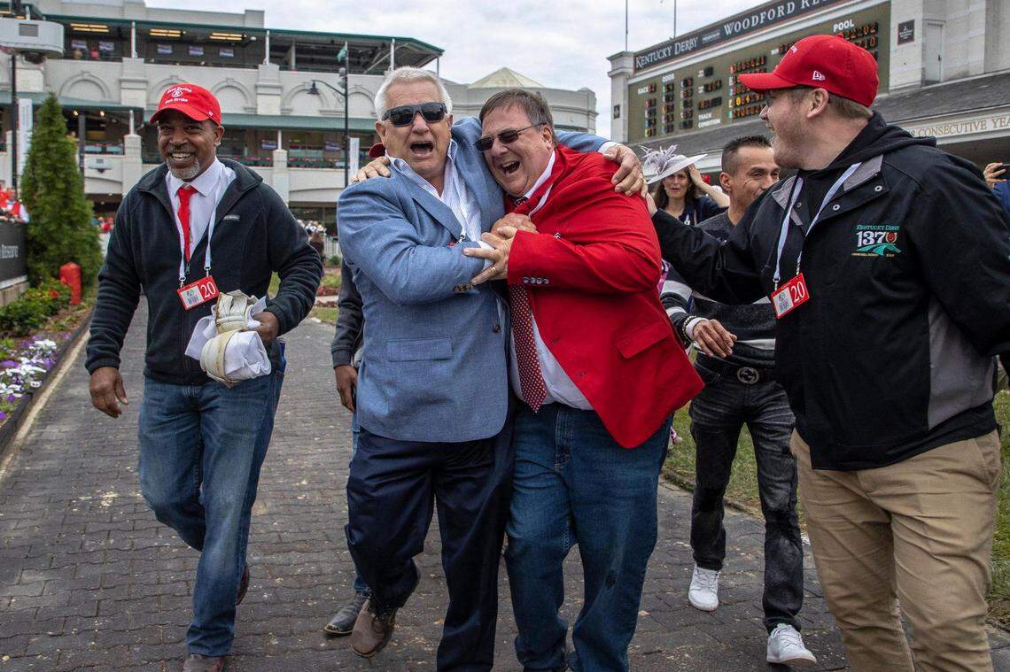 Rich Strike trainer Eric Reed, in red, celebrates with friends and family including Ken Tyson in blue, in the paddock after their horse finish line at Churchill Downs in Louisville, Ky., Saturday, May 7, 2022.