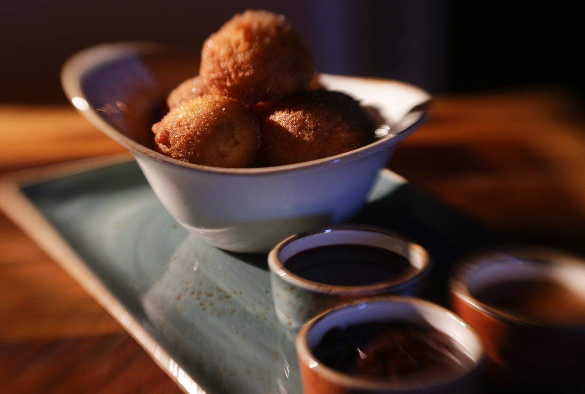 Warm donut holes with cinnamon sugar dusting and chocolate, raspberry melba, salted caramel dipping sauces.