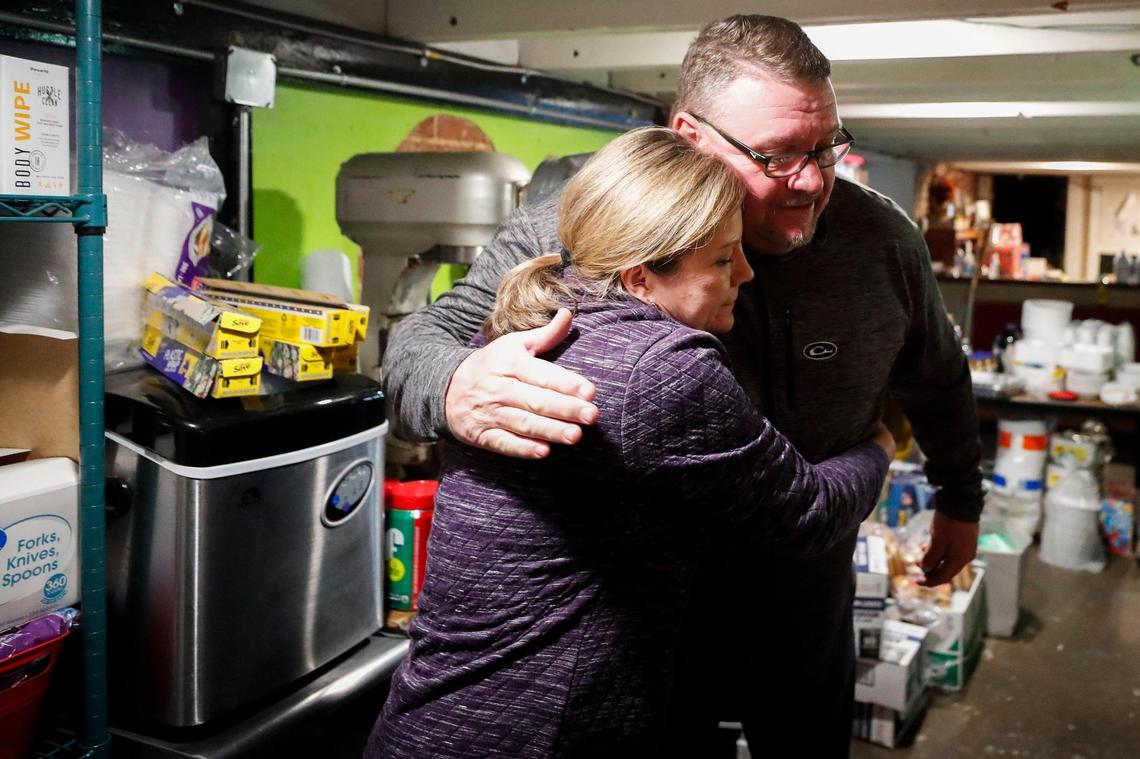 Volunteers Michele Hill, of Madisonville, Ky., embraces Lance Johnson, of Granger, Ga., as they work in the Redemption City Church donation center in Dawson Springs, Ky., Monday, Dec. 13, 2021. The Redemption City shelter is currently located on East Arcadia Avenue and is accepting donations including food, water and clothing.