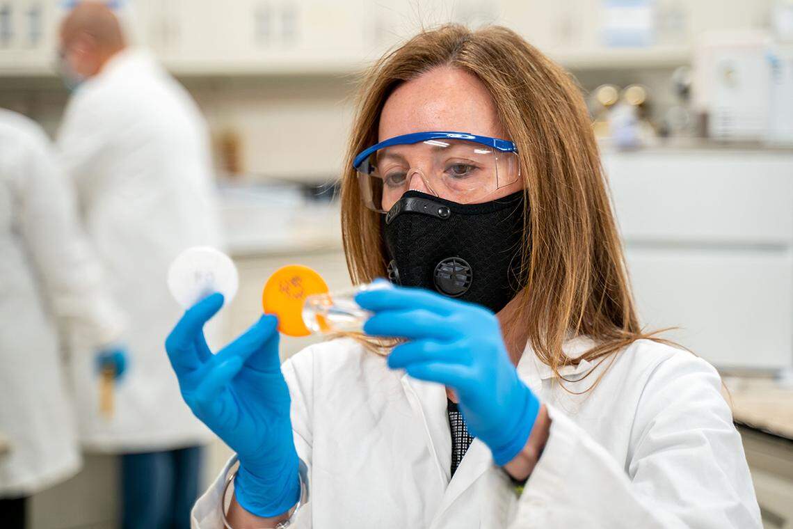 Isabel Escobar, a professor in chemical and materials engineering, holds two versions of the plastic support lattice and a vial of the membrane material to inactivate the COVID-19 virus.