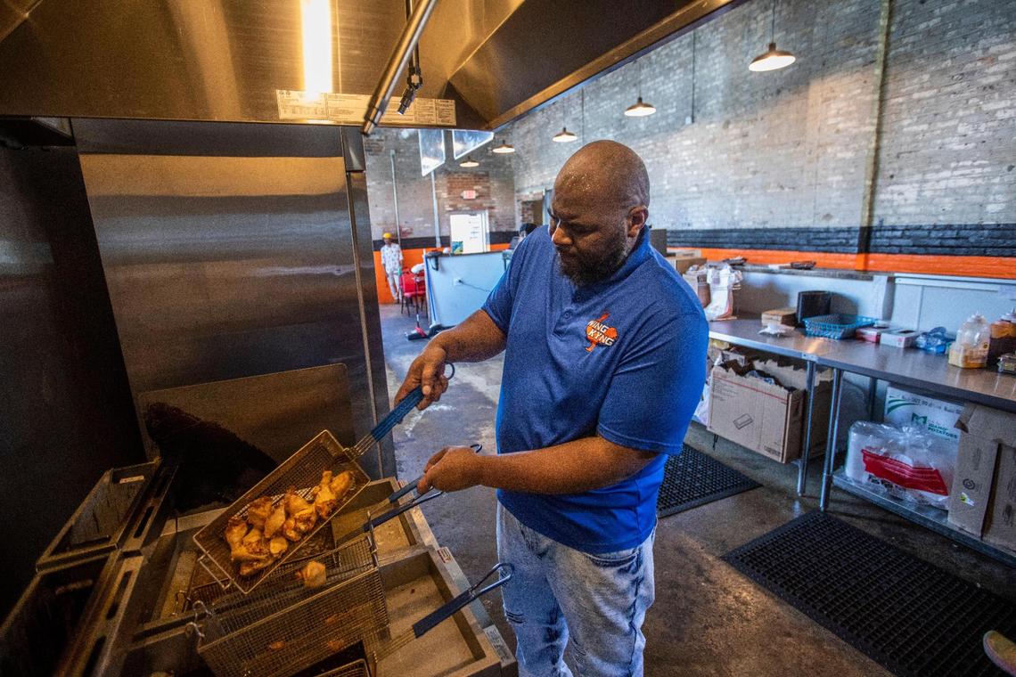 Thomas Williams, the owner of Wing KYng, works to make wings in the kitchen of his storefront at Greyline Station in Lexington, Ky., Thursday, May 11, 2023.