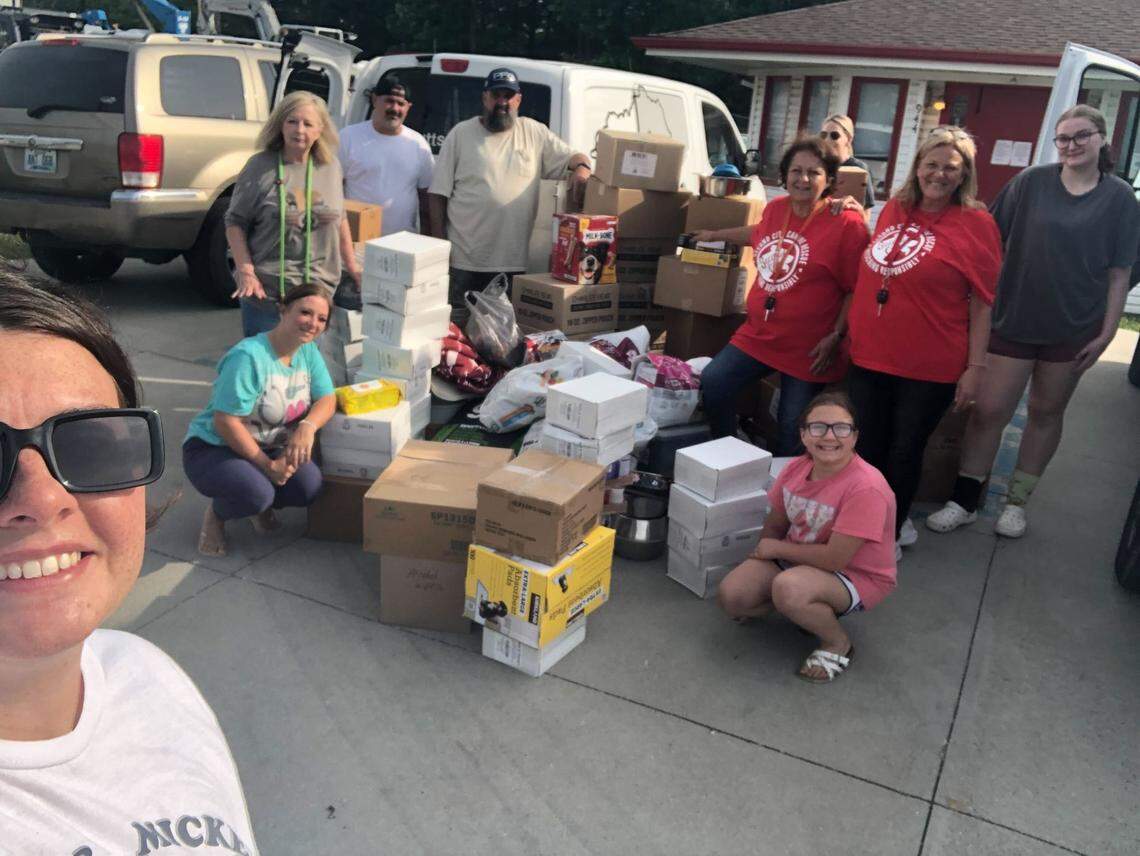 A group of volunteers pose for a photo with supplies for rescued animals