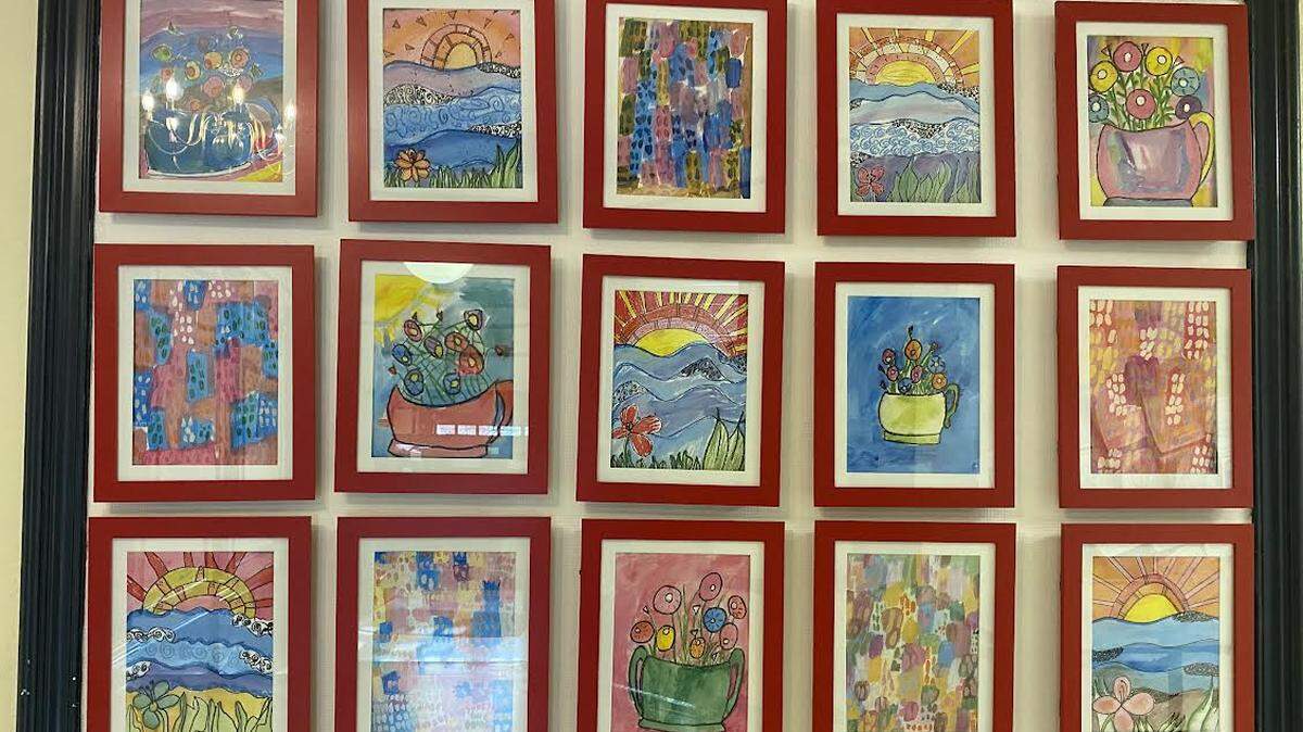 Artwork done by Cassidy Elementary Art Club members hangs up on a wall for display.