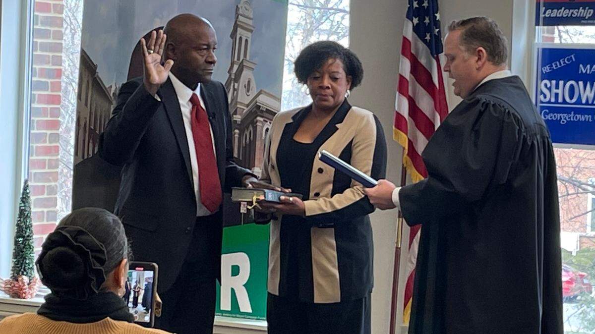 Burney Jenkins, left, is sworn in by Judge Jeremy Maddox, right, as Georgetown’s first black mayor on Sunday afternoon at his alma mater, Georgetown College.