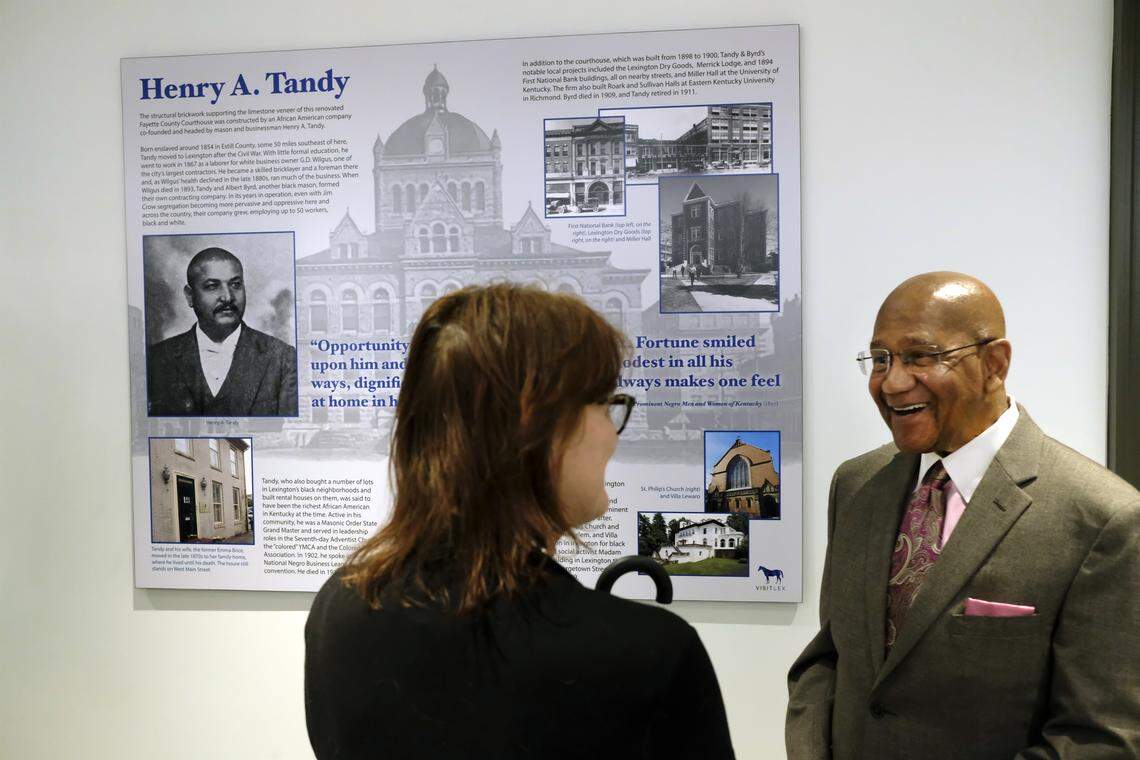 P.G. Peeples, president and CEO of the Urban League of Lexington-Fayette County, chats with Celeste Lewis, director of the Pam Miller Downtown Arts Center, after the unveiling of a panel in the old Fayette County Courthouse telling the story of mason Henry A. Tandy. Born a slave, Tandy became one of Kentucky’s most successful black businessmen. His masonry company did the brick infrastructure for the courthouse in 1899, as well as many other buildings from that era around Lexington.