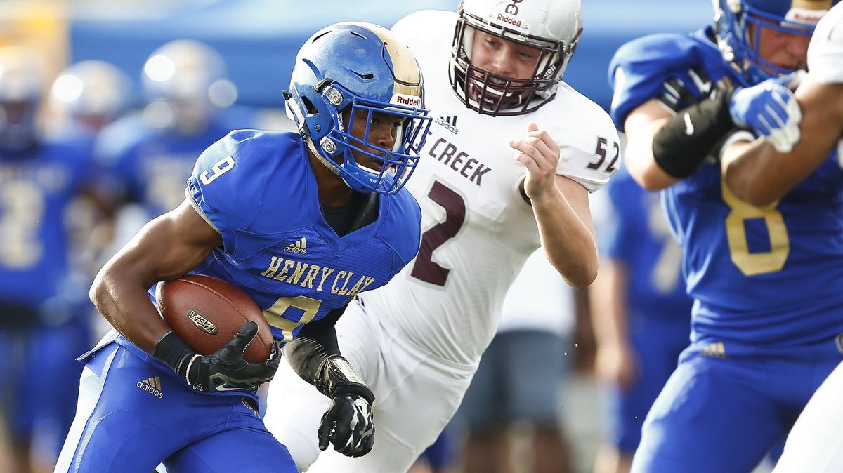Henry Clay’s Langston Jackson (9) ran the ball past Tates Creek’s Noah James (52).