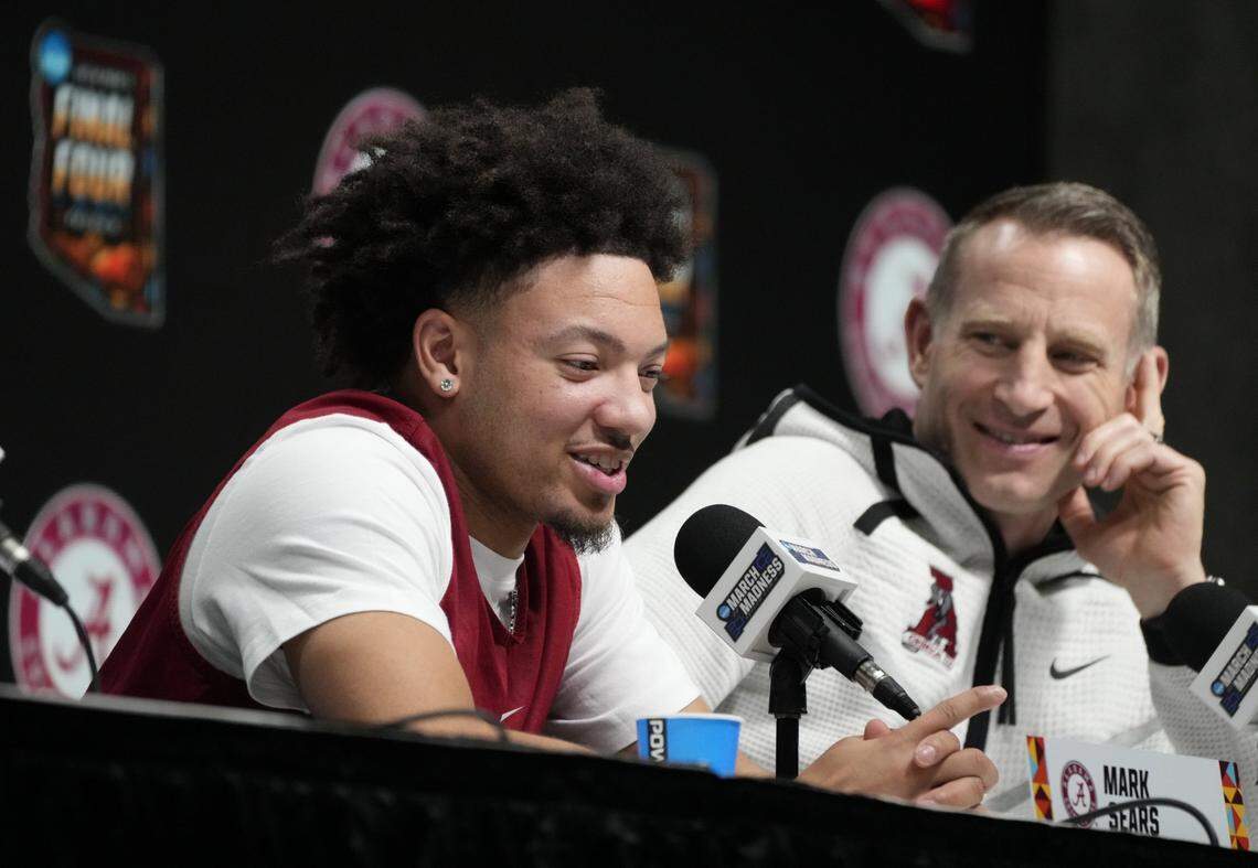Alabama coach Nate Oats, right, looks on as star player Mark Sears speaks to reporters during a press conference at the Final Four.