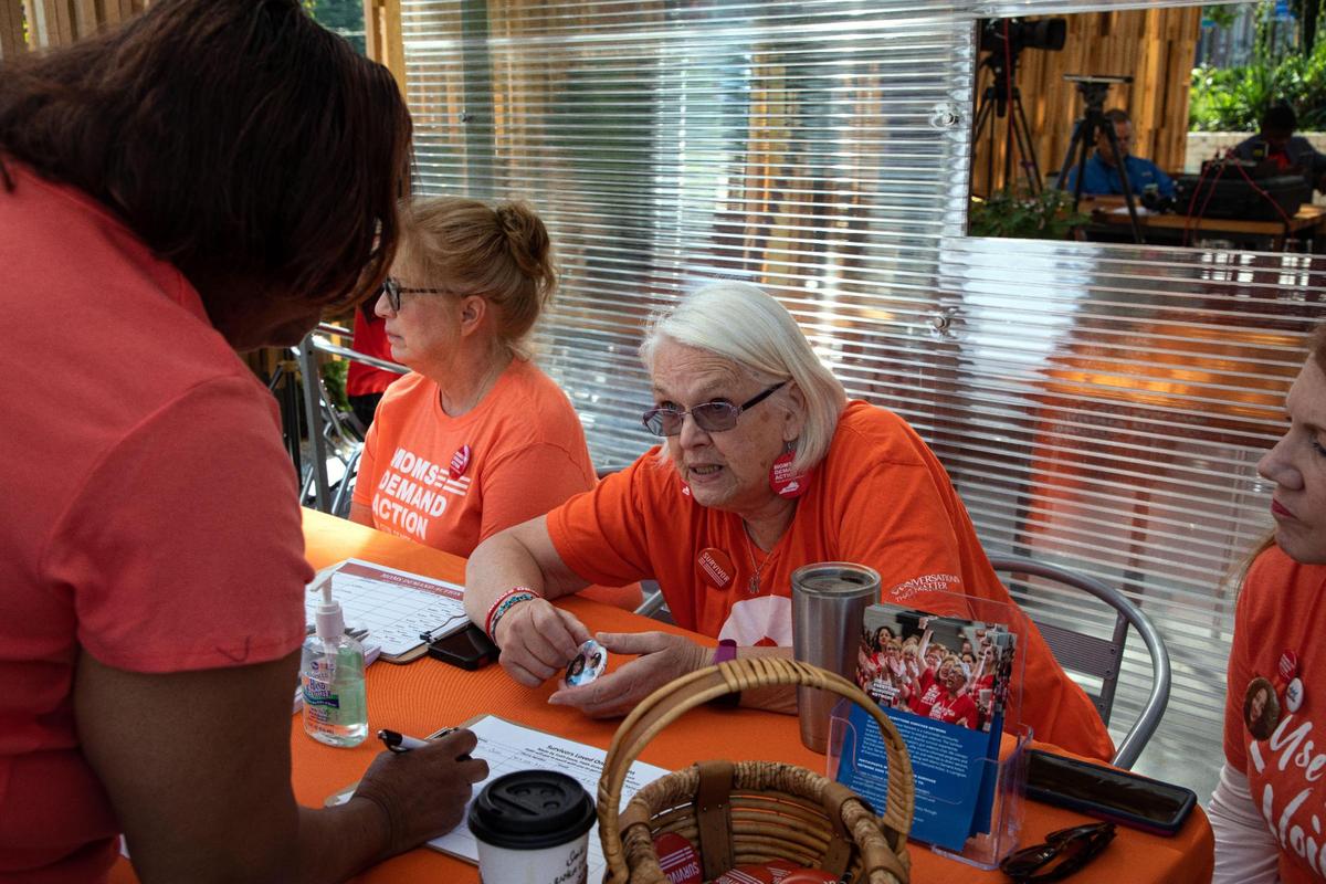 Volunteer with Moms Demand Action Diane Cahill showed buttons a fellow volunteer makes for families of gun violence victims during a rally against gun violence held by the group Friday at Sav’s Restaurant.