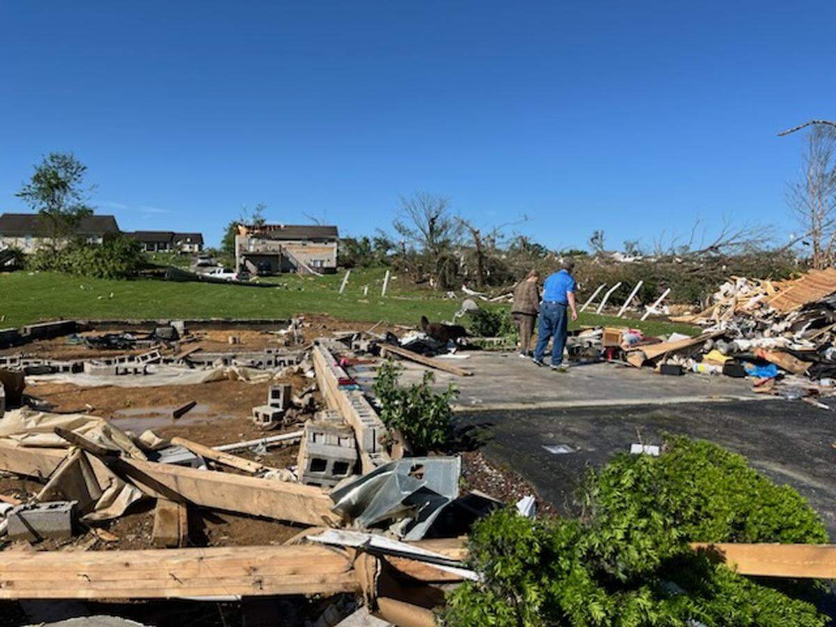 Jennifer Adams and her neighbor look through the remains of Adams’ house, which was ripped off its foundation by significant storms and a presumed tornado in the Sunshine Hills area of Laurel County in Kentucky early May 17, 2025.