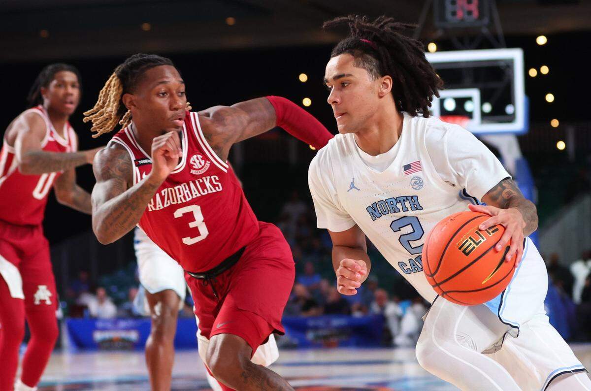 Nov 24, 2023; Paradise Island, BAHAMAS; North Carolina Tar Heels guard Elliot Cadeau (2) drives to the basket as Arkansas Razorbacks guard El Ellis (3) defends during the first half at Imperial Arena. Mandatory Credit: Kevin Jairaj-USA TODAY Sports
