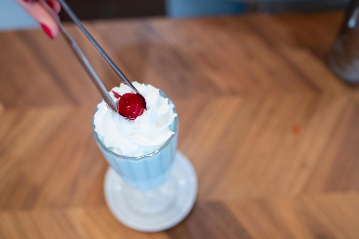Ella Martin puts the final touches on a cotton candy shake for a customer at Freshie’s Ice Cream & Soda Fountain in Lexington, Ky., Wednesday, November 30, 2022.