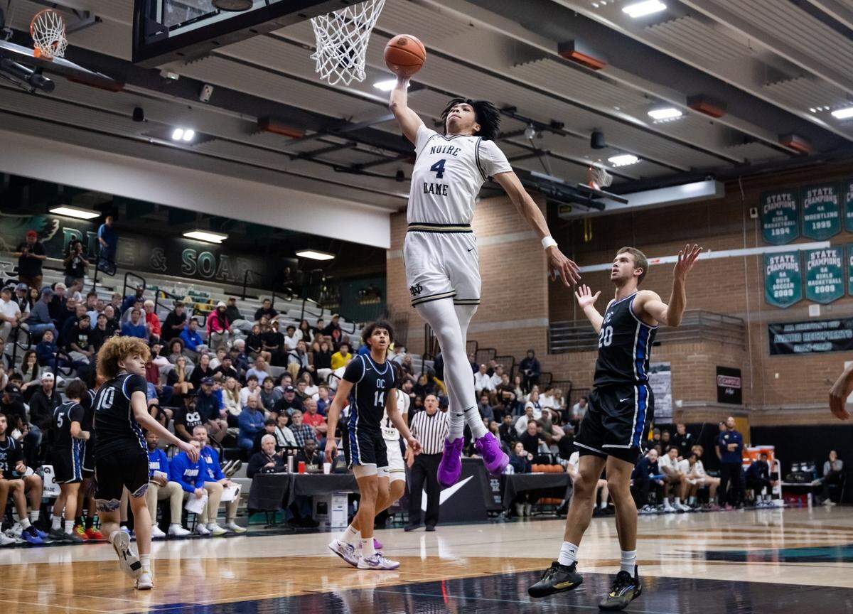 Jan 4, 2025; Gilbert, AZ, USA; Notre Dame High School (CA) forward Tyran Stokes (4) slam dunks the ball as Sandra Day O'Connor (AZ) forward Michael Simcoe (20) reacts during the Hoophall West High School Invitational at Highland High School. Mandatory Credit: Mark J. Rebilas-Imagn Images