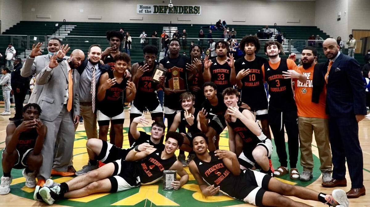 Frederick Douglass players celebrate by holding up three fingers for their third straight 42nd District Tournament championship after beating Henry Clay at Bryan Station High School on Friday night.