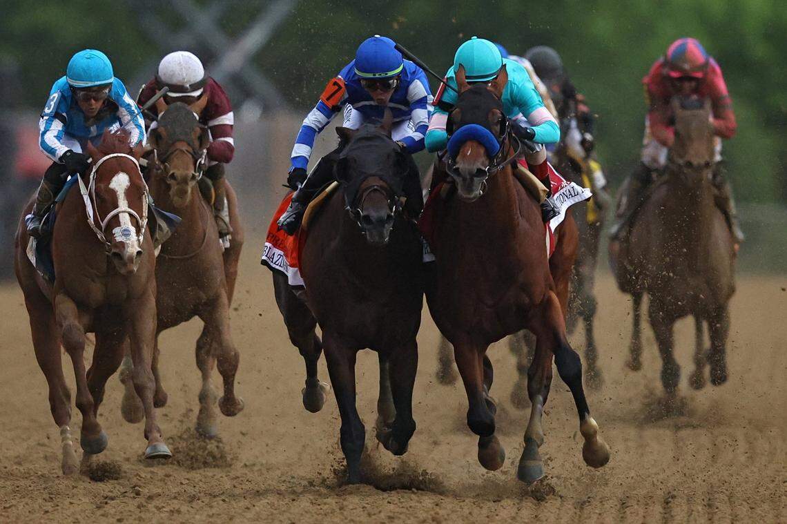 Jockey John Velazquez atop National Treasure, right, rides alongside Irad Ortiz Jr. aboard Blazing Sevens as the two close in on the finish line Saturday. National Treasure won by a head.
