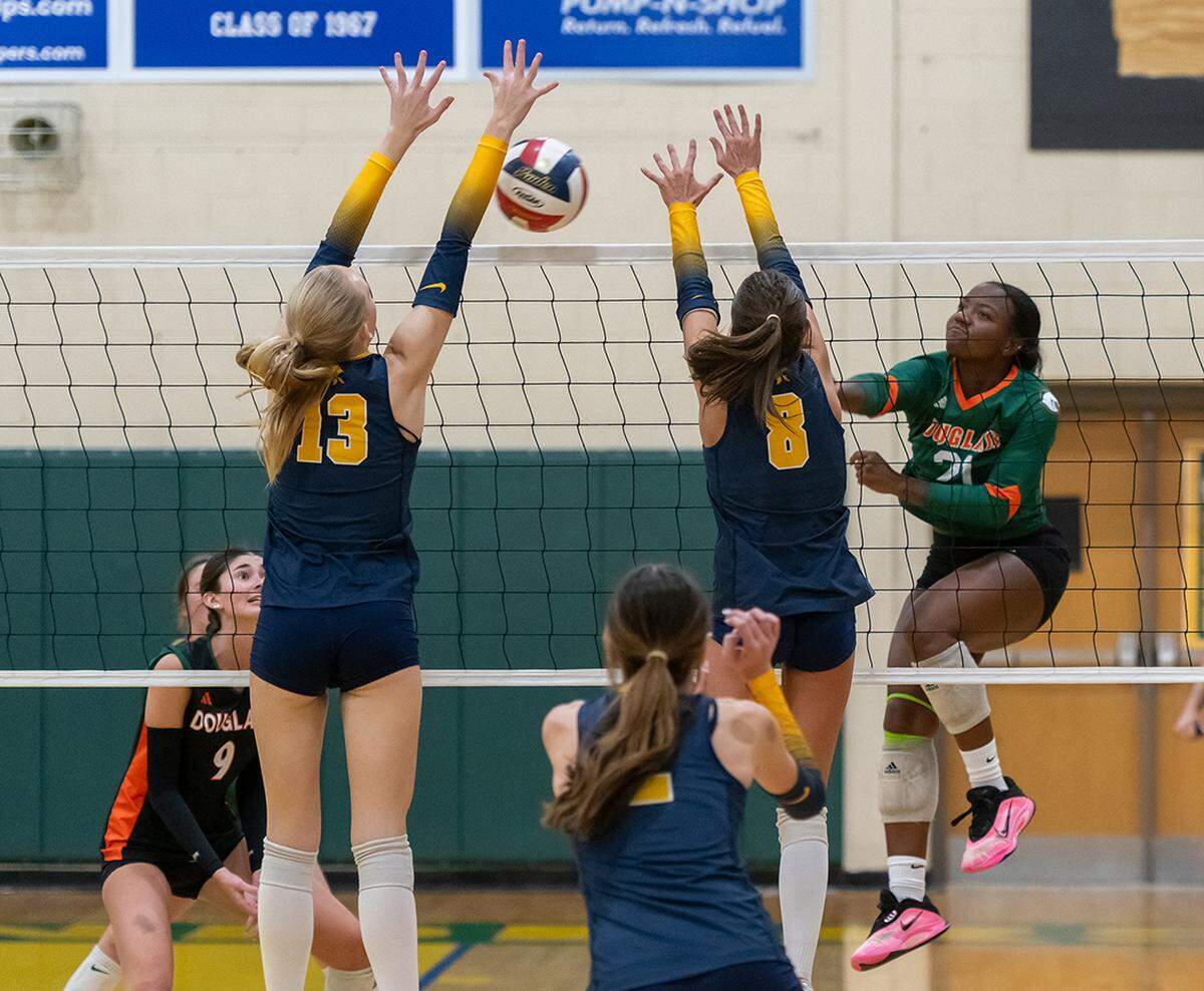 Frederick Douglass' Urijah Holman-Allen smashes a kill attempt against Sayre's Aubrey Greathouse (13) and Ellie Hiler (8) during the Broncos' 3-1 win against Sayre in the 43rd District girls volleyball tournament championship game Thursday at Bryan Station High School.