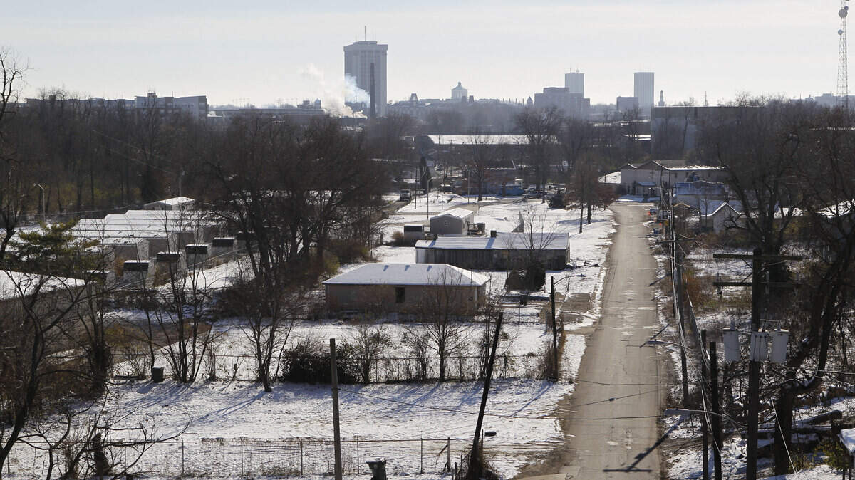 Eighteen manufactured homes, left, house about 15 families of 50 to 60 people in the Davis Bottoms area near De Roode Street. At right are the remains of the old houses.  