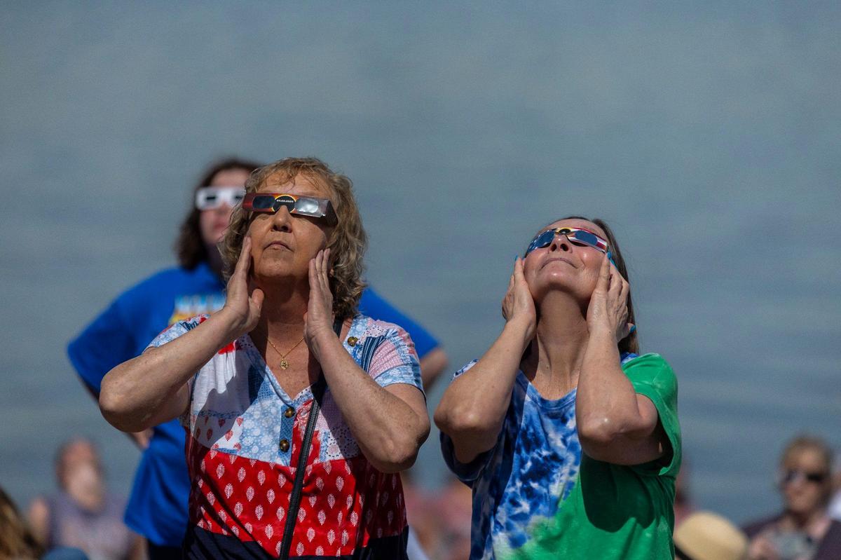 Spectators watch a solar eclipse on the riverfront in Paducah, Ky., on Monday, April 8, 2024.