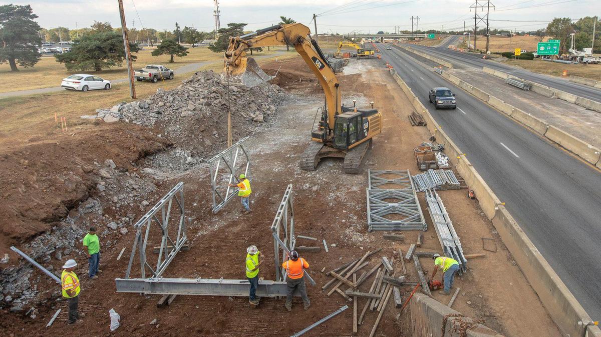 Workers construct a temporary bridge between the two main Lexmark buildings on New Circle Road in Lexington, Ky., Tuesday, Oct. 1, 2019. The temporary pedestrian bridge is being constructed so a permanent pedestrian bridge can be built over New Circle Road. The bridge is a key part of the Legacy Trail.