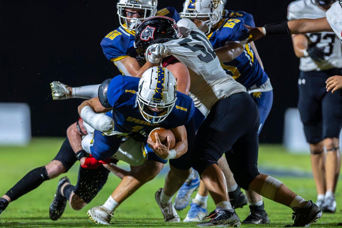 Sayre’s Charlie Slabaugh (1) is wrapped up by Ludlow’s Spencer Brandenburg (3) during a game in Lexington on Sept. 6.