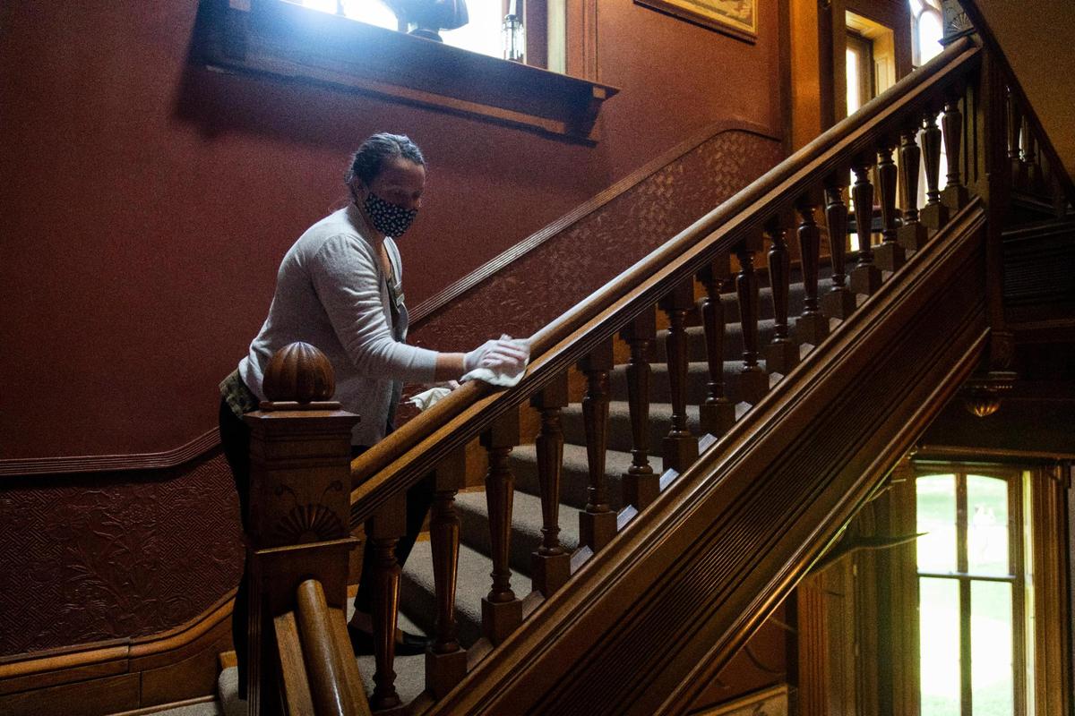 Manager of Tours and Education, Cameron Walpole, cleans railing and other high-touch surfaces throughout the Ashland: The Henry Clay Estate in Lexington, Ky., Wednesday, August, 2020. Staff at the estate clean between each tour to ensure that the house is safe for the next tour and other staff members to work.
