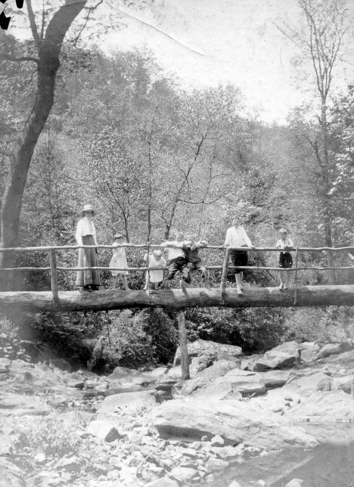 Pine Mountain Settlement School teacher and students standing on log bridge during school’s early years in Pine Mountain, Ky. Credit: Pine Mountain Settlement School Archives